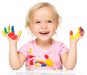 Image showing Portrait of a cute little girl playing with paints