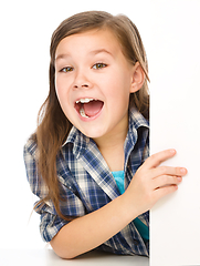 Image showing Little girl is looking from out blank board