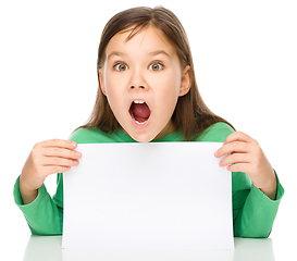 Image showing Little girl is looking out from the blank banner