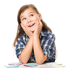 Image showing Girl is writing on color stickers using pen