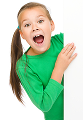 Image showing Little girl is looking from out blank board