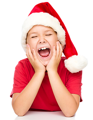 Image showing Little girl in santa hat is daydreaming