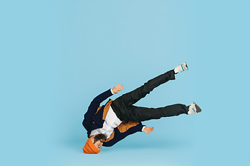 Image showing Businessman having fun dancing break dance on blue background at work