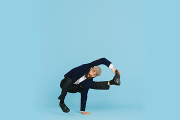 Image showing Businessman having fun dancing break dance on blue background at work