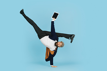 Image showing Businessman having fun dancing break dance on blue background at work