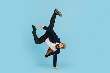 Image showing Businessman having fun dancing break dance on blue background at work