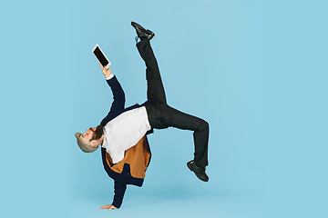 Image showing Businessman having fun dancing break dance on blue background at work