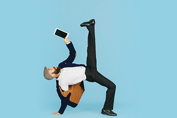 Image showing Businessman having fun dancing break dance on blue background at work