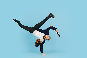 Image showing Businessman having fun dancing break dance on blue background at work
