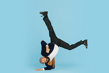 Image showing Businessman having fun dancing break dance on blue background at work