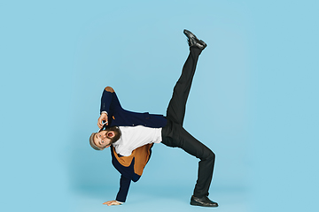 Image showing Businessman having fun dancing break dance on blue background at work