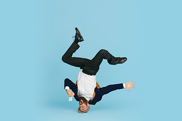 Image showing Businessman having fun dancing break dance on blue background at work