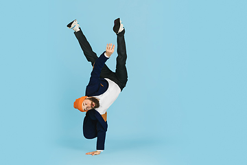 Image showing Businessman having fun dancing break dance on blue background at work