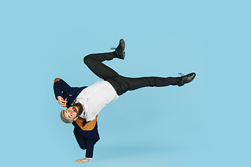 Image showing Businessman having fun dancing break dance on blue background at work