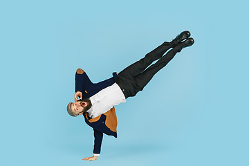 Image showing Businessman having fun dancing break dance on blue background at work