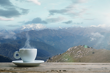 Image showing Single tea or coffee mug and landscape of mountains on background