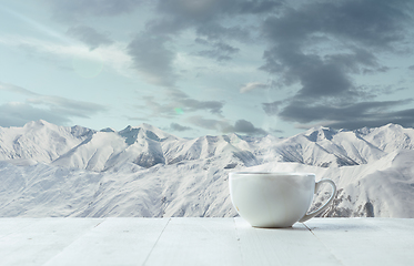 Image showing Single tea or coffee mug and landscape of mountains on background