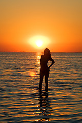 Image showing Silhouette of the young woman on a gulf on a sunset
