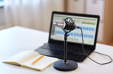 Image showing microphone, laptop and notebook on table