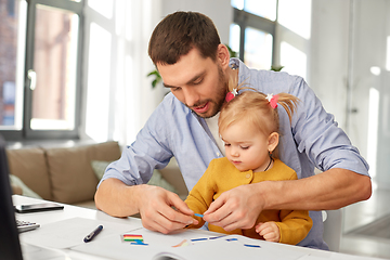 Image showing working father with baby daughter at home office