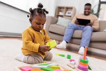 Image showing african baby girl playing with toy blocks at home