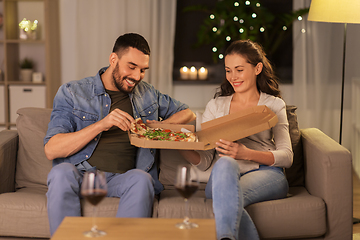 Image showing happy couple eating takeaway pizza at home