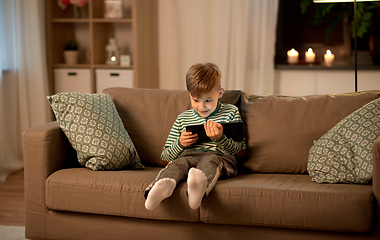 Image showing happy little boy with tablet computer at home