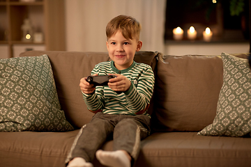 Image showing little boy with gamepad playing video game at home