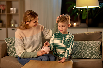 Image showing mother and little son with piggy bank at home