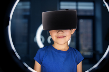 Image showing boy in vr glasses over illumination in dark room