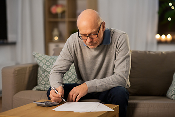 Image showing senior man with bills and calculator at home