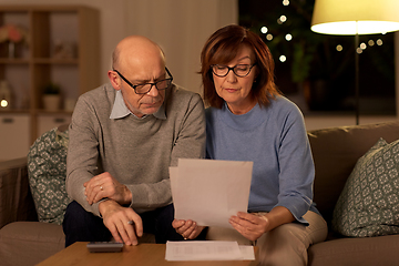 Image showing senior couple with papers and calculator at home