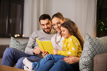 Image showing happy family reading book at home at night