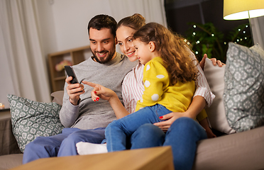 Image showing happy family with smartphone at home at night