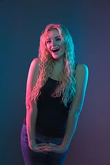 Image showing Caucasian young woman\'s portrait on gradient background in neon light