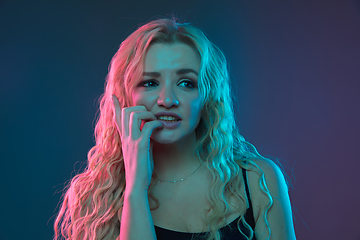 Image showing Caucasian young woman\'s portrait on gradient background in neon light