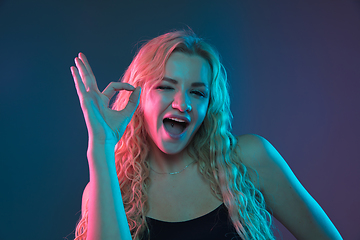 Image showing Caucasian young woman\'s portrait on gradient background in neon light