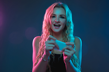 Image showing Caucasian young woman\'s portrait on gradient background in neon light