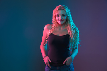 Image showing Caucasian young woman\'s portrait on gradient background in neon light