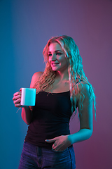 Image showing Caucasian young woman\'s portrait on gradient background in neon light