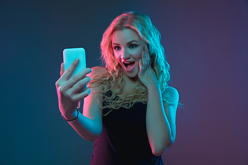 Image showing Caucasian young woman\'s portrait on gradient background in neon light