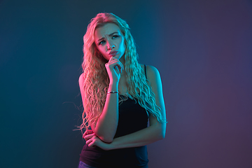 Image showing Caucasian young woman\'s portrait on gradient background in neon light