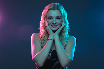 Image showing Caucasian young woman\'s portrait on gradient background in neon light