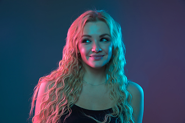 Image showing Caucasian young woman\'s portrait on gradient background in neon light