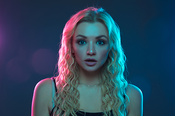 Image showing Caucasian young woman\'s portrait on gradient background in neon light