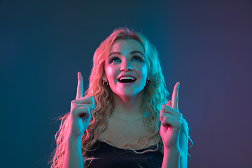 Image showing Caucasian young woman\'s portrait on gradient background in neon light