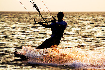 Image showing Silhouette of a kitesurfer on a waves