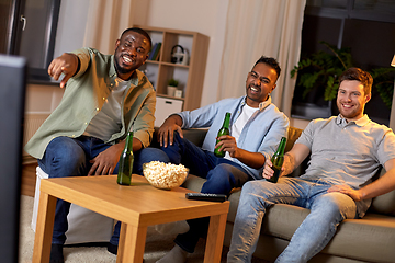 Image showing happy male friends with beer watching tv at home