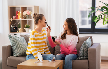 Image showing happy teenage girls doing make up at home