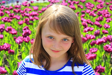 Image showing portrait of little girl stand by lilac tulips